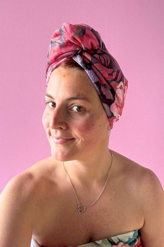 Woman wearing a floral hairwrap against a pink background