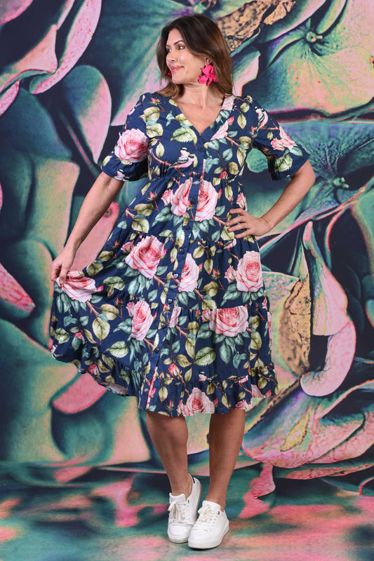 Woman wearing a floral dress posing against a colorful abstract background