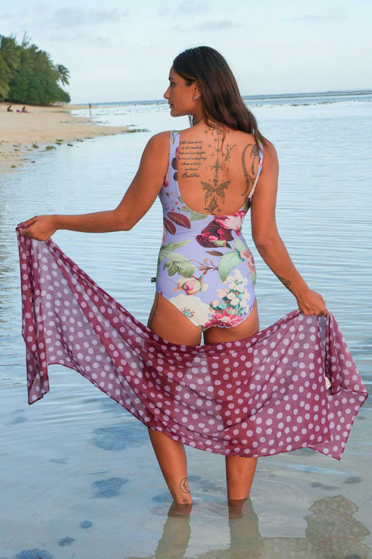 Woman in a floral swimsuit with a polka dot cover-up on a beach