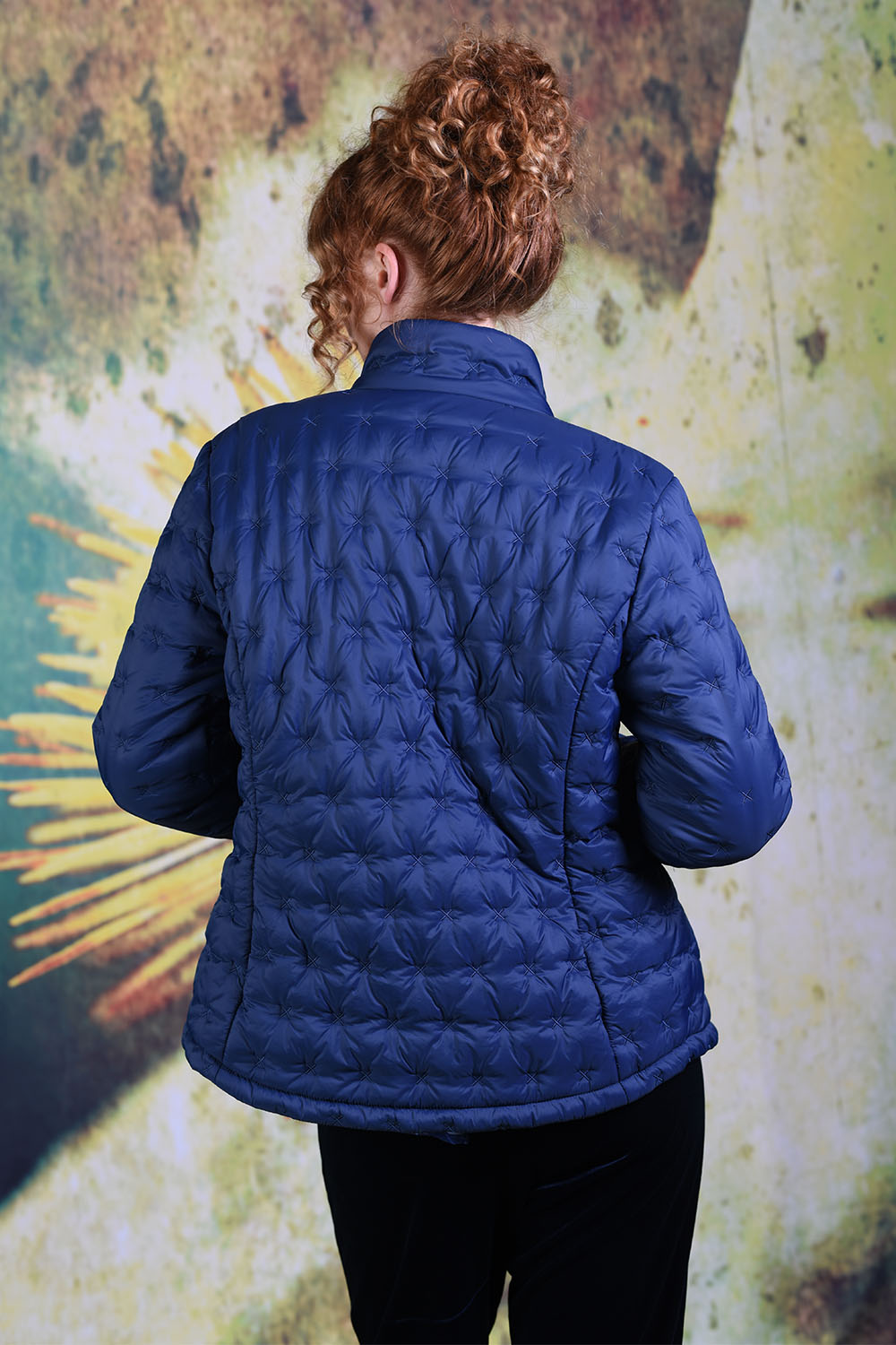 Back of model wearing the Annah Stretton Ambrosia Puffer Jacket in navy