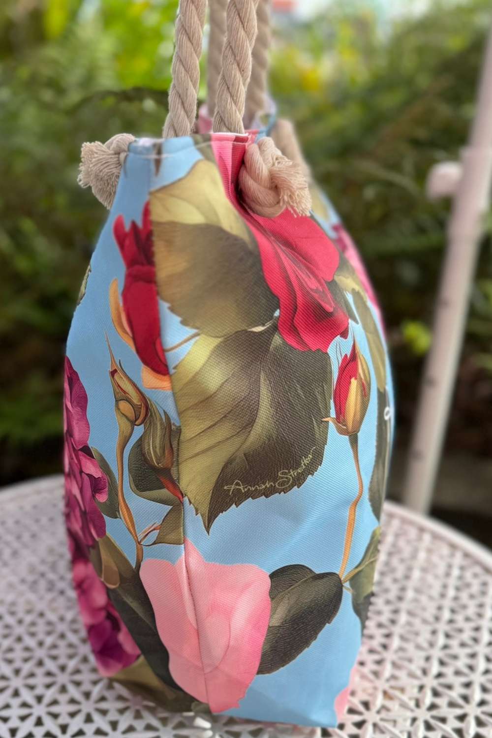 Floral-patterned bag with a blue background on a white surface