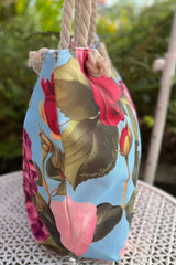 Floral-patterned bag with a blue background on a white surface