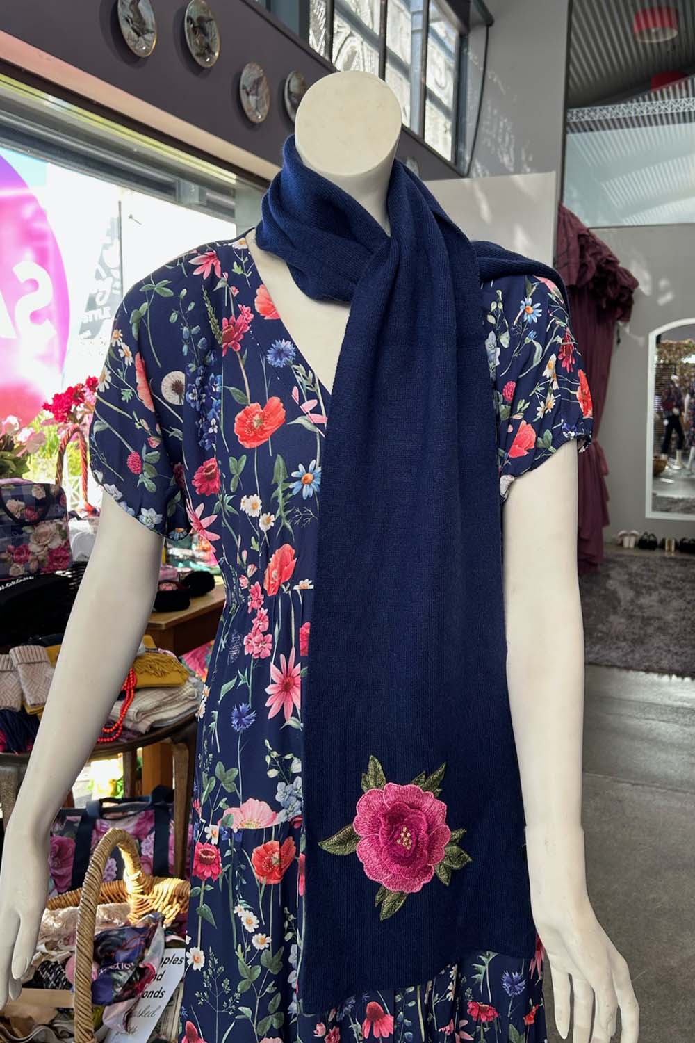 The Annah Stretton Freya Cashmere Scarf hanging down on a mannequin