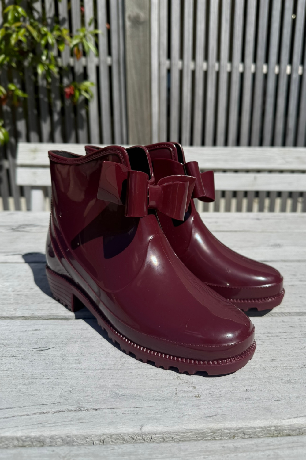 Pair of burgundy rain boots with bows