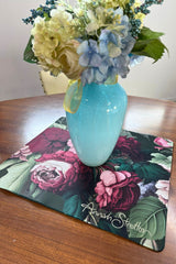 Turquoise vase with flowers on a floral placemat