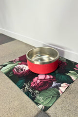 Red pet bowl on a floral Annah Stretton mat.