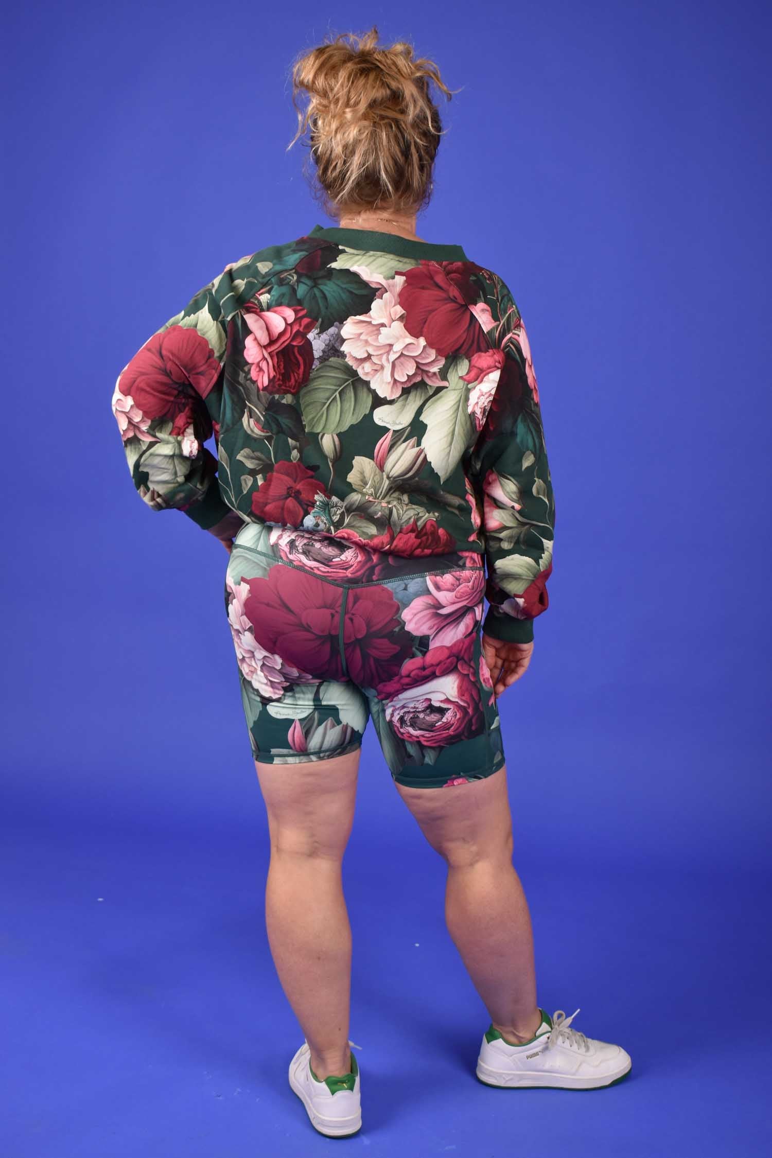 Person wearing a floral activewear set on a blue background