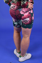 Person wearing floral shorts on a blue background