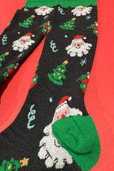 Christmas-themed socks with Santa Claus and trees on a red background