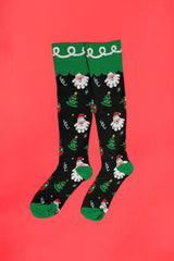 Christmas-themed knee-high socks with Santa Claus and trees on a red background