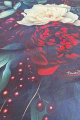Close-up of Midnight Holly table runner – red, ivory, and green holiday blooms