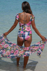 Georgie Bather Gingham Bloom Annah Stretton – back view showing open back, frill cap sleeves, and Gingham Bloom print, styled with flowing matching sarong coverup at beach