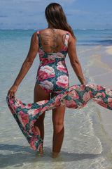 Erika Bather Vintage Peonies Annah Stretton – back view showing low open back, wide straps, and large-scale pink and coral peony floral print on deep teal, styled with matching wrap at beach