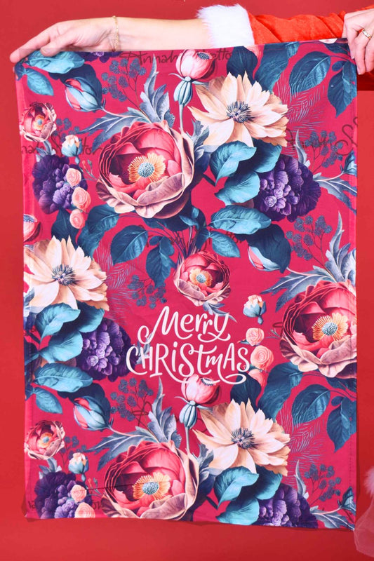 Floral Christmas-themed tea towel with 'Merry Christmas' text on a red background