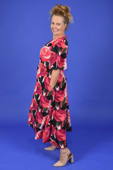 Side view of floral occasion dress with pockets by Annah Stretton