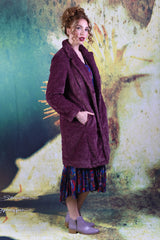 Side of model wearing the Annah Stretton Adoring Iris Coat in wine, showcasing it's pockets