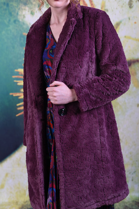 Close-up of fluffy wine-coloured fabric on the Annah Stretton Adoring Iris Coat