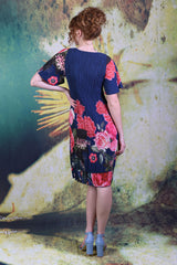 Model facing the back, wearing the Pleat Me Juliet Dress in peony