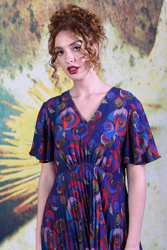 Closer shot of multi-coloured blue and red rose floral pattern on Annah Stretton Talor dress in mad rose