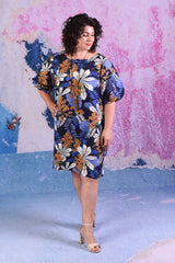 model wearing delta puff sleeve tropical print navy dress