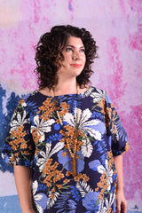 model wearing delta puff sleeve tropical print navy dress